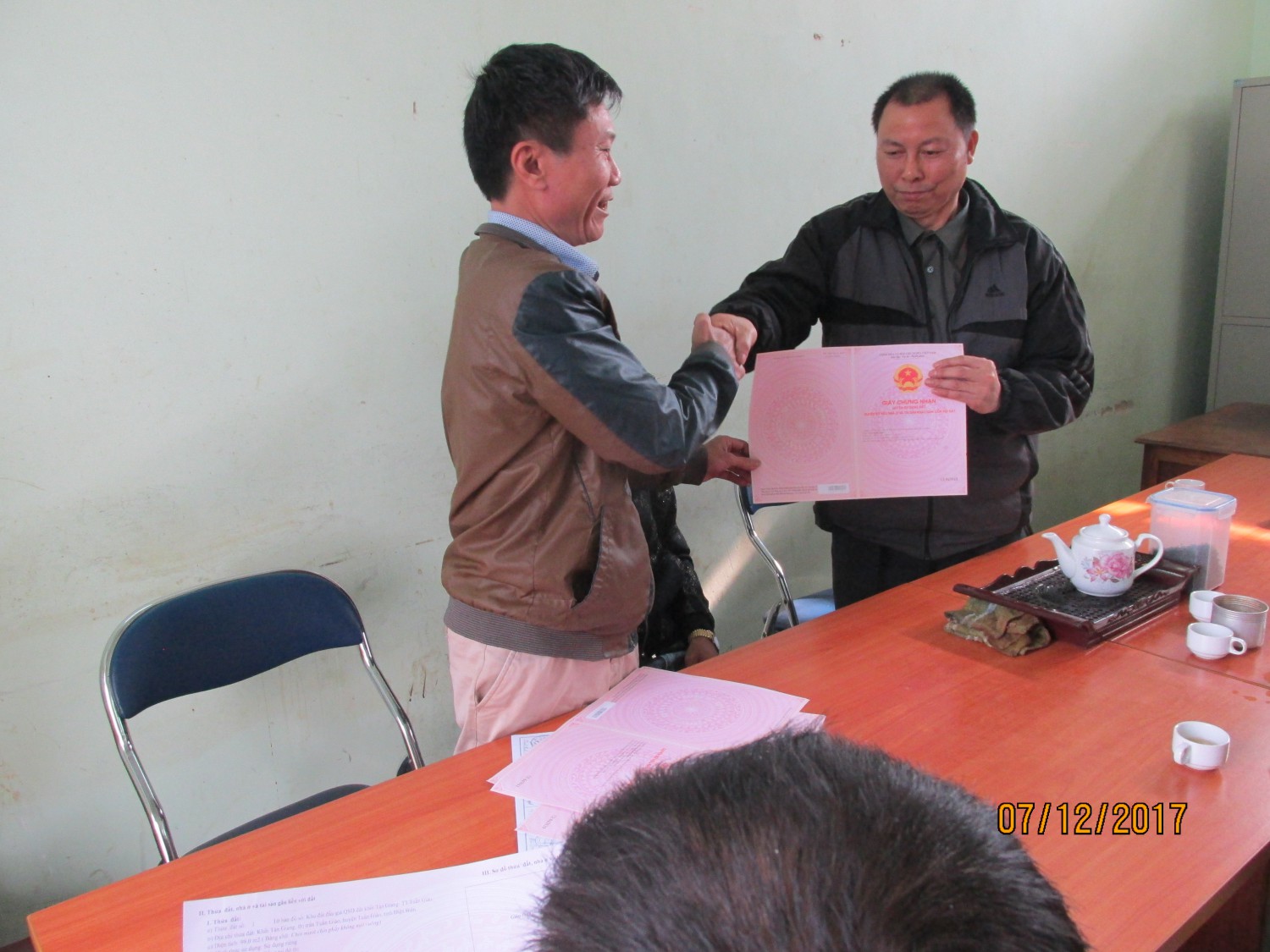 Đại diện phòng TNMT trao giấy CNQSD đất cho ông Trần Xuân Giao